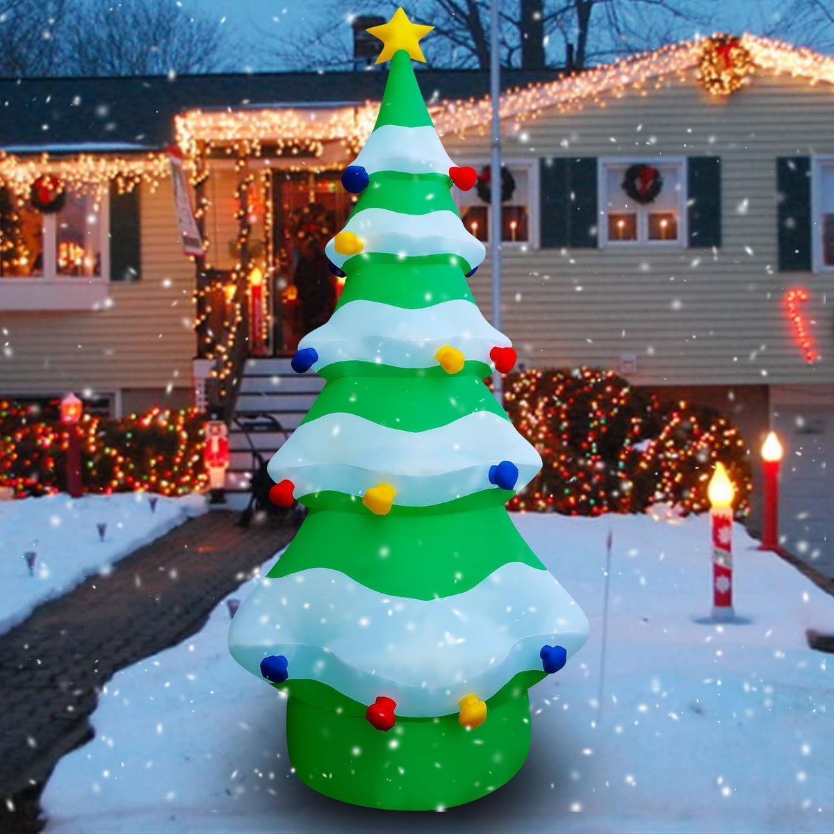 Tall green Christmas tree inflatable with snowy tiers and a gold star in a snowy yard