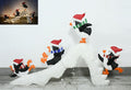 Four penguins in Santa hats on a white snow slide decoration