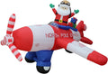 Santa waving from a red and white North Pole Express propeller plane inflatable