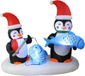 Two penguins in Santa hats ice fishing on a snowy base, one holding up a blue fish