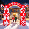 Red and white gift box arch inflatable with a Merry Christmas banner and two kids under it in the snow