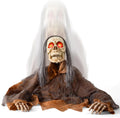 Skull-faced zombie ghoul with gray hair and red eyes crawling out of the ground in brown rags