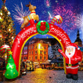 Red Merry Christmas arch inflatable with a reindeer on top, Santa and a tree in a lit town square