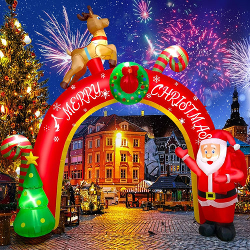 Red Merry Christmas arch inflatable with a reindeer on top, Santa and a tree in a lit town square