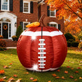 Football-print pumpkin inflatable with white laces on a fall lawn