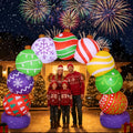 Arch of colorful patterned ornament ball inflatables with a family in holiday sweaters beneath it